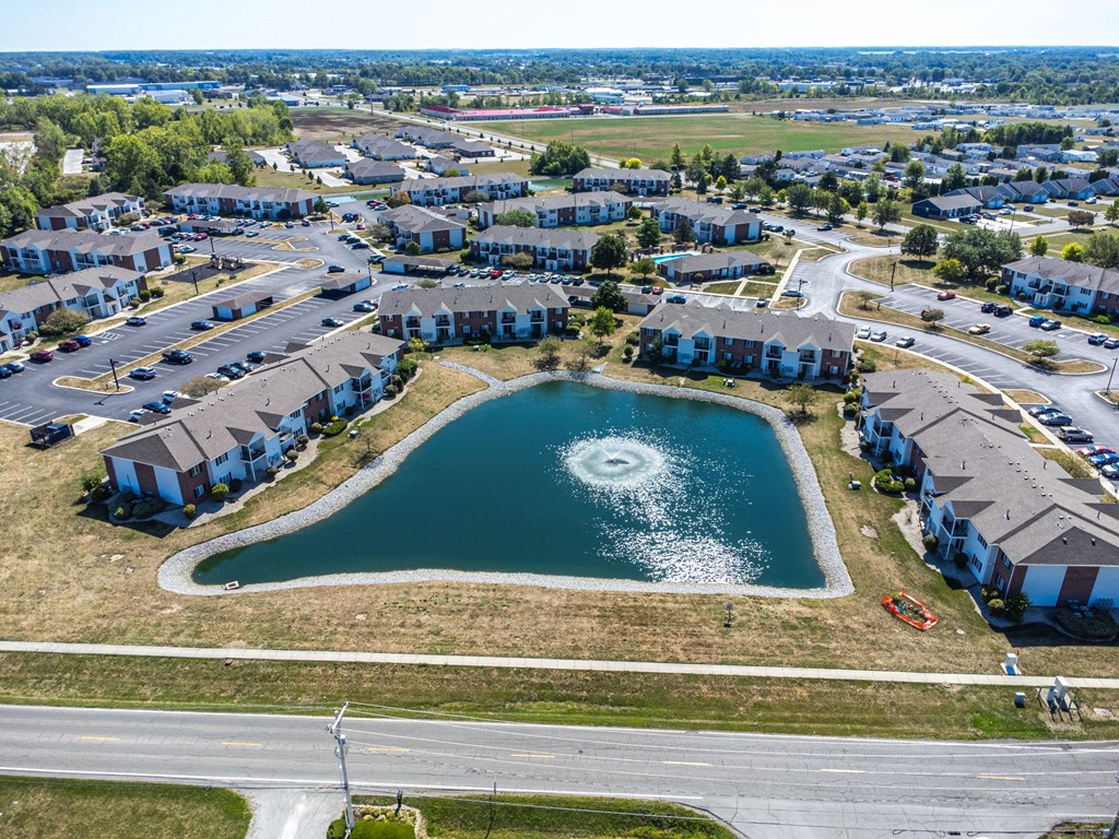 A bird's eye view of a residential area with a lake in the middle.