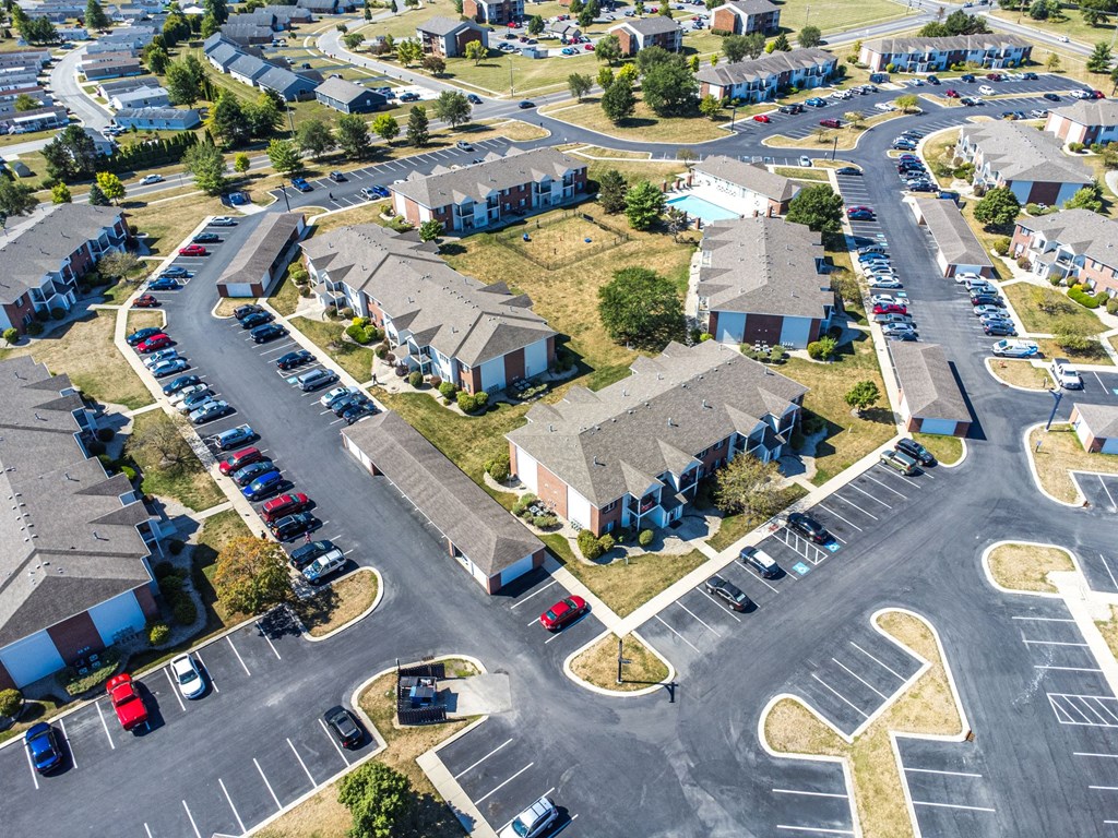 A parking lot with cars and apartment buildings in the background.