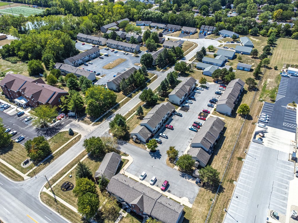 A bird's eye view of a residential area with houses and parked cars.