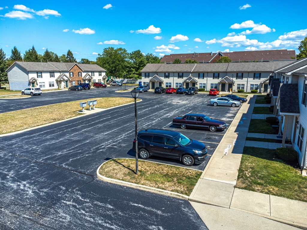 A parking lot with cars and a building in the background.