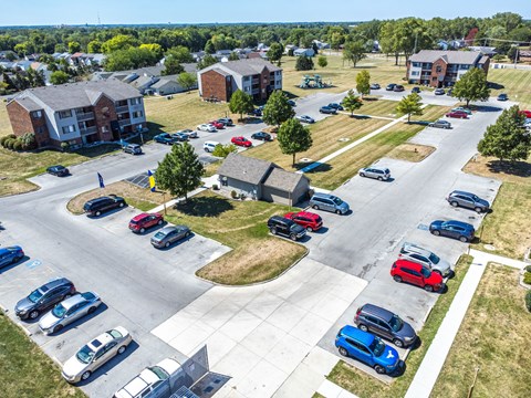 A parking lot with cars and apartment buildings in the background.