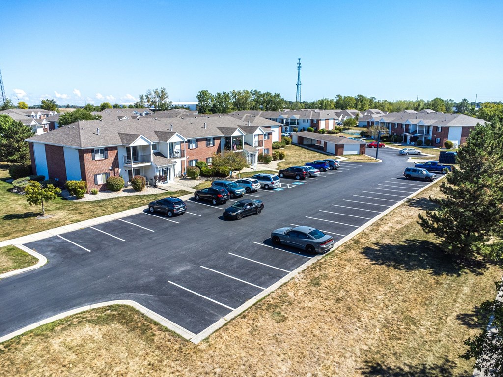 A parking lot with cars and apartment buildings in the background.