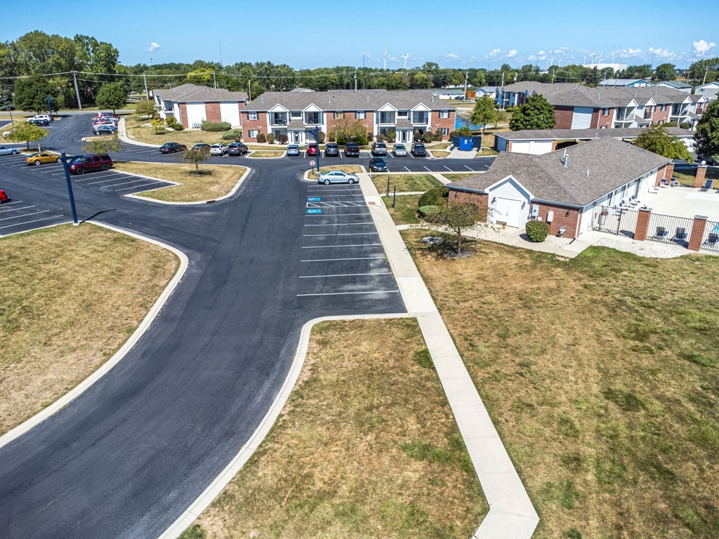 A road with a white line on the side and cars parked on the side.