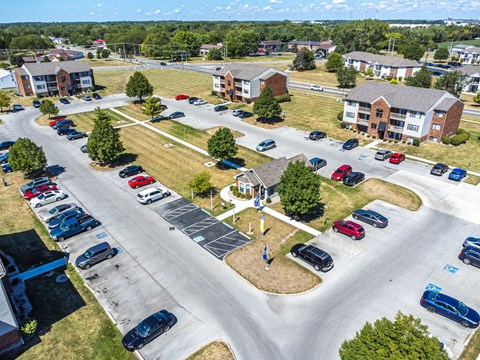 A parking lot with cars and a small building in the background.