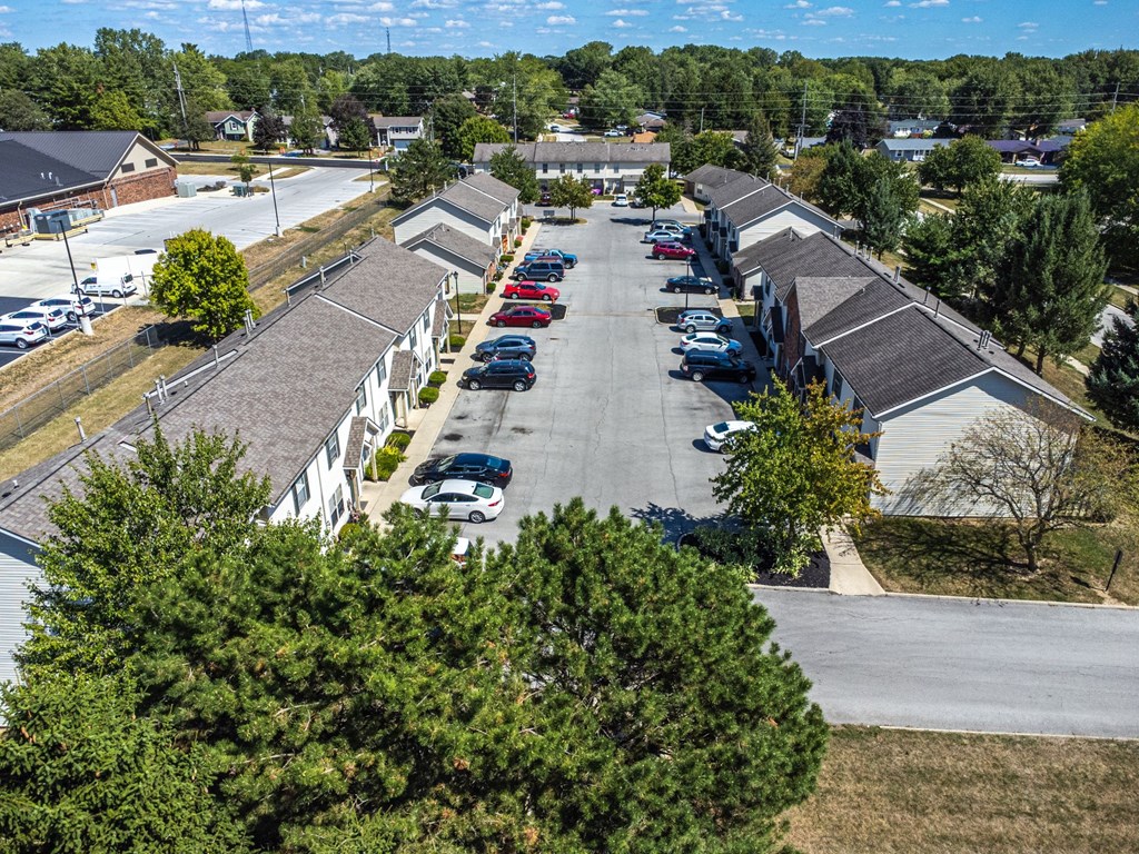 A parking lot with cars and apartment buildings in the background.