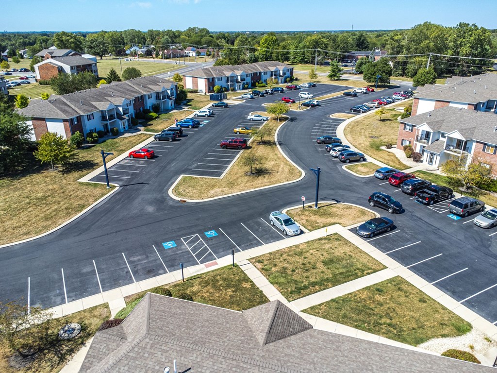 A parking lot with cars and apartment buildings in the background.