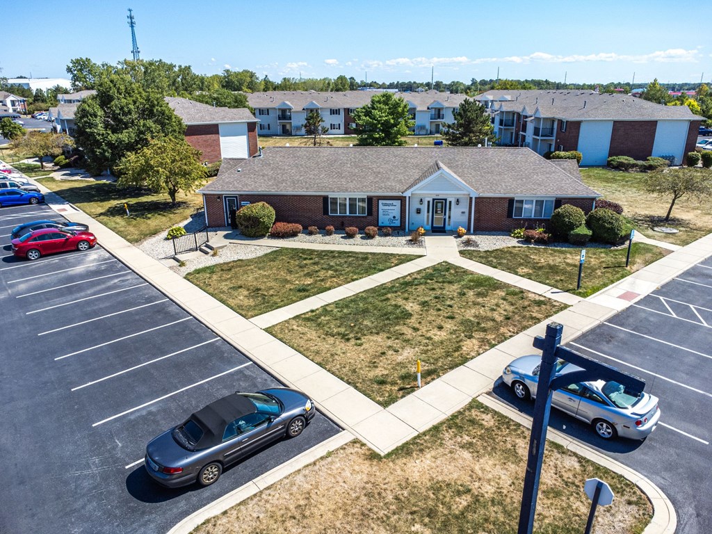A parking lot with cars and a building in the background.