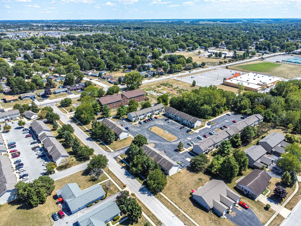 A bird's eye view of a residential area with houses and a parking lot.