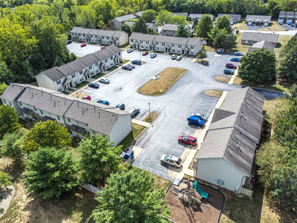 A parking lot surrounded by buildings and trees.