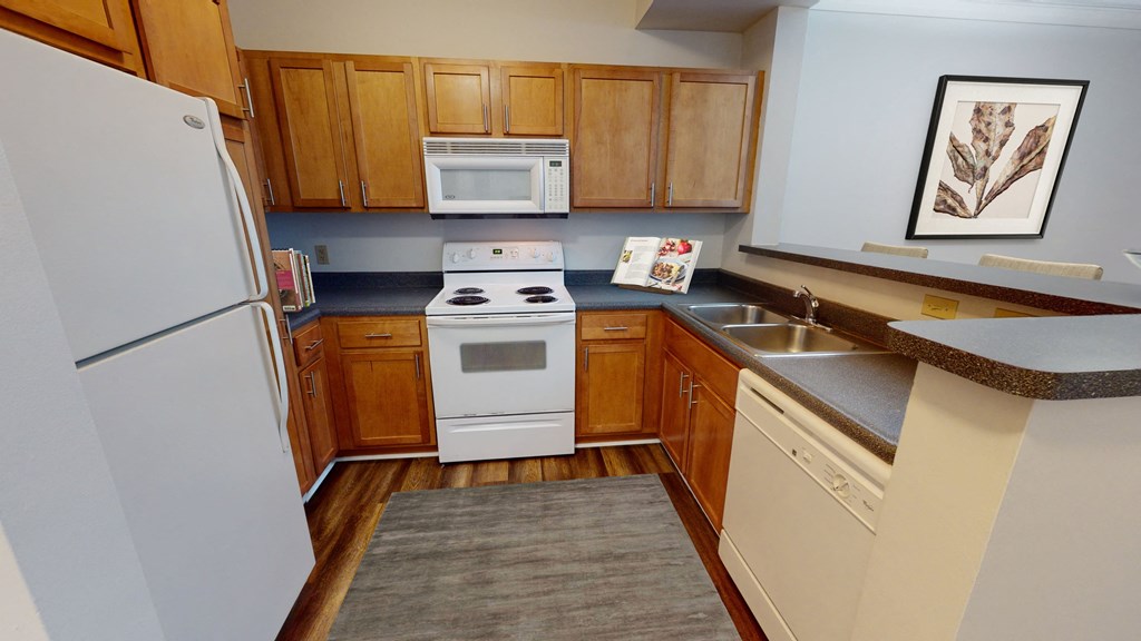 a kitchen with a white refrigerator freezer next to a white stove top oven