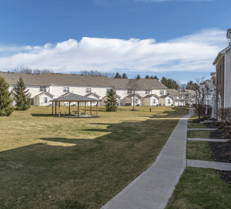 a park with a gazebo in front of a row of houses at Traditions at Slate Ridge, Reynoldsburg, OH