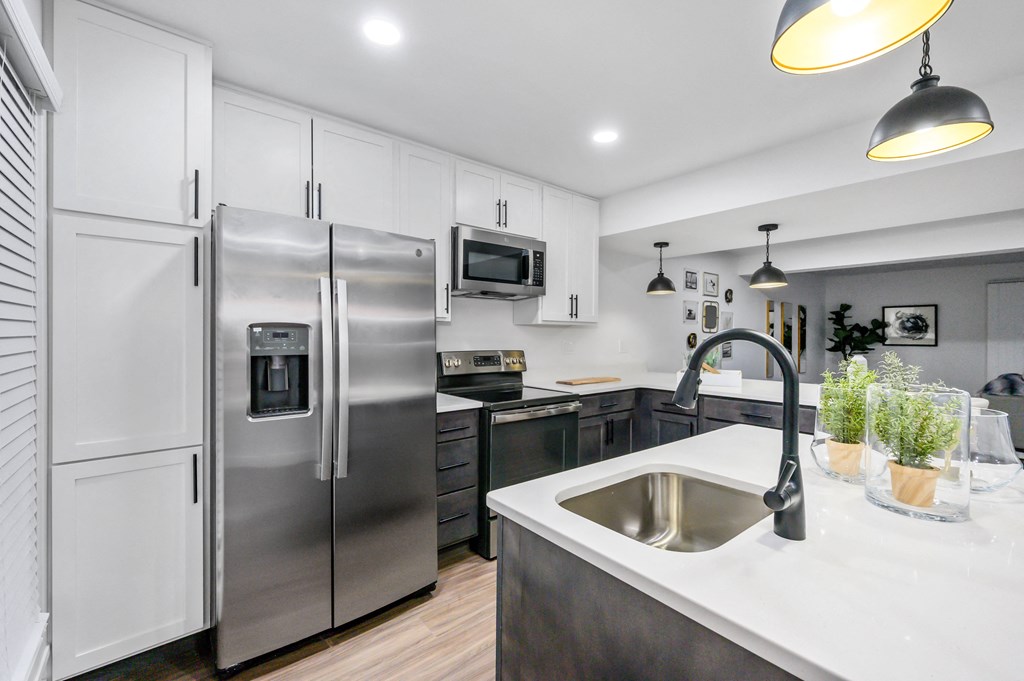 a kitchen with white cabinets and stainless steel appliances