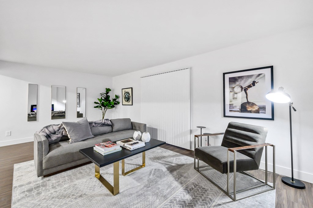 a living room with white walls and hardwood floors