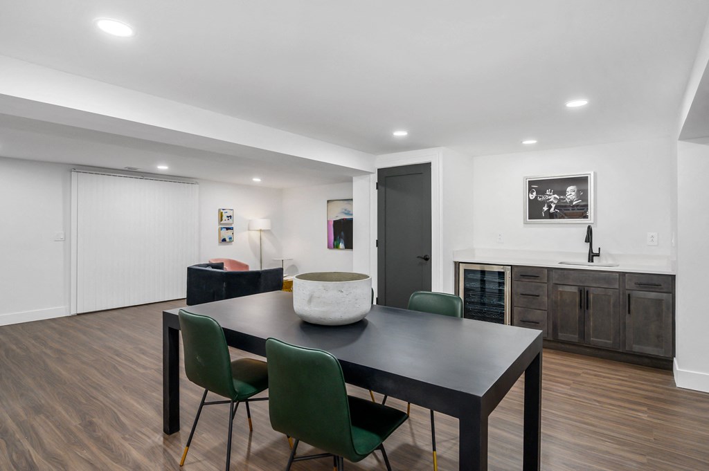 a dining area with a table and chairs and a kitchen in the background