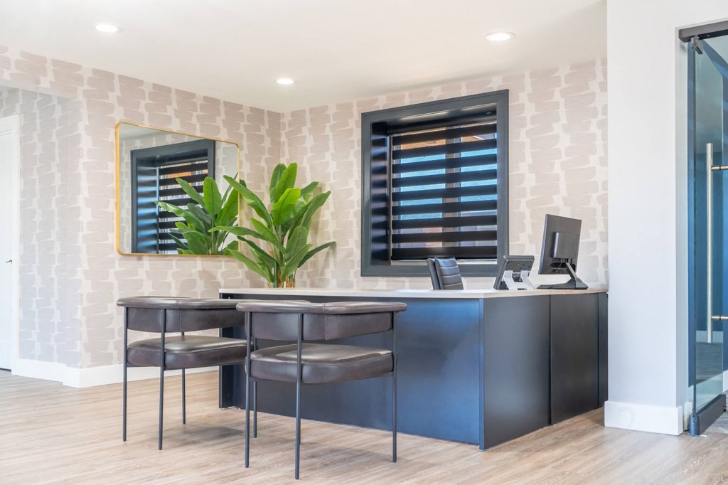 an office with two stools and a desk with a computer
