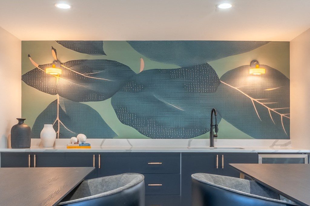 a kitchen with blue cabinets and a painting on the wall