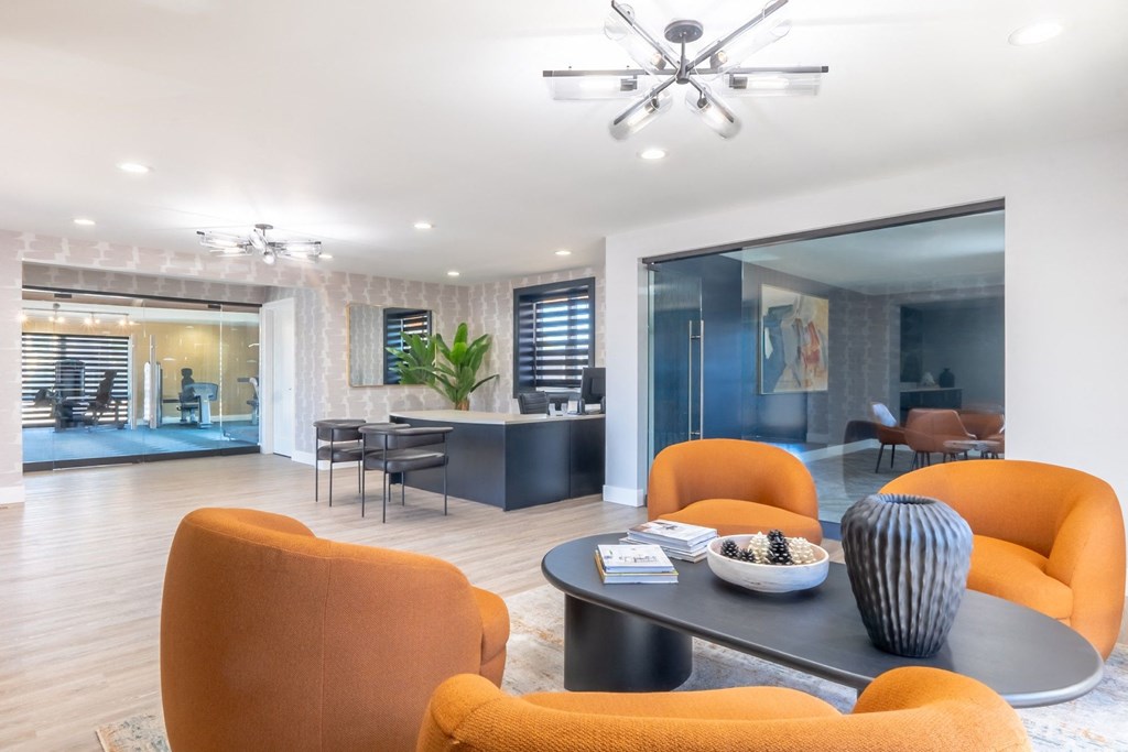 a living room with orange chairs and a table