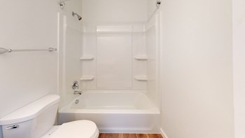 a bathroom with a white toilet and a white bathtub - Photo Gallery 37