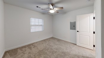 a bedroom with a ceiling fan and a door - Photo Gallery 35