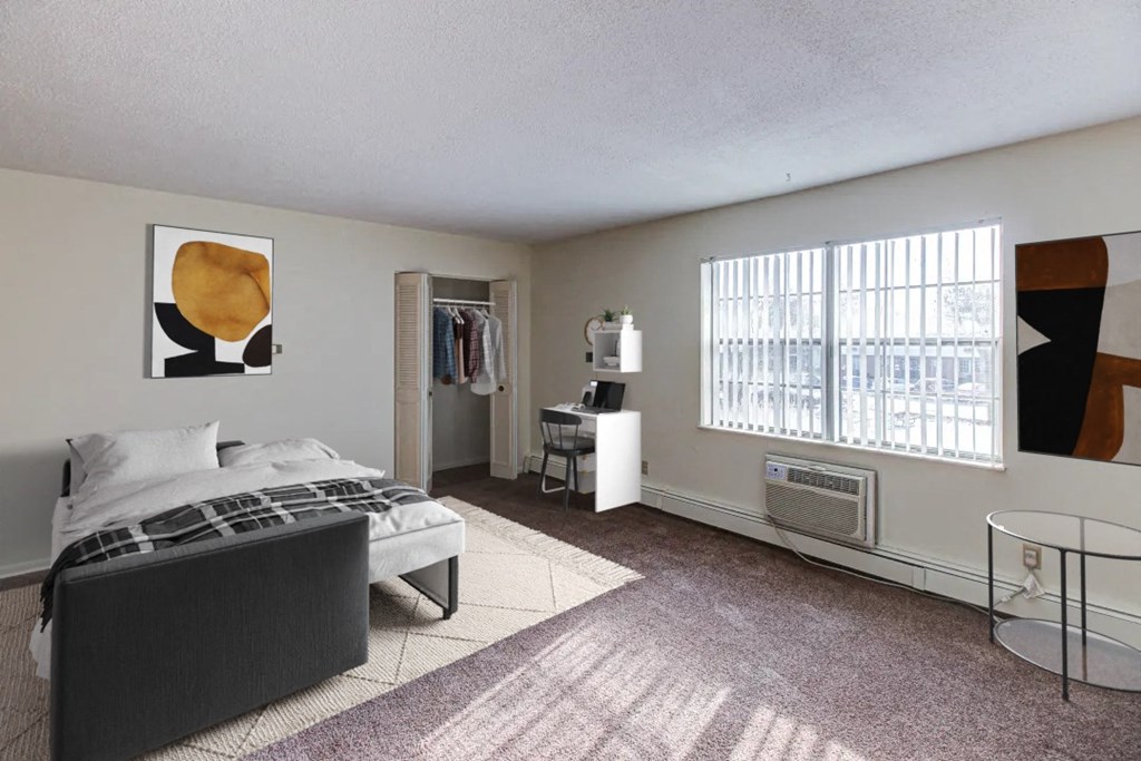 a bedroom with a bed and a desk in a room