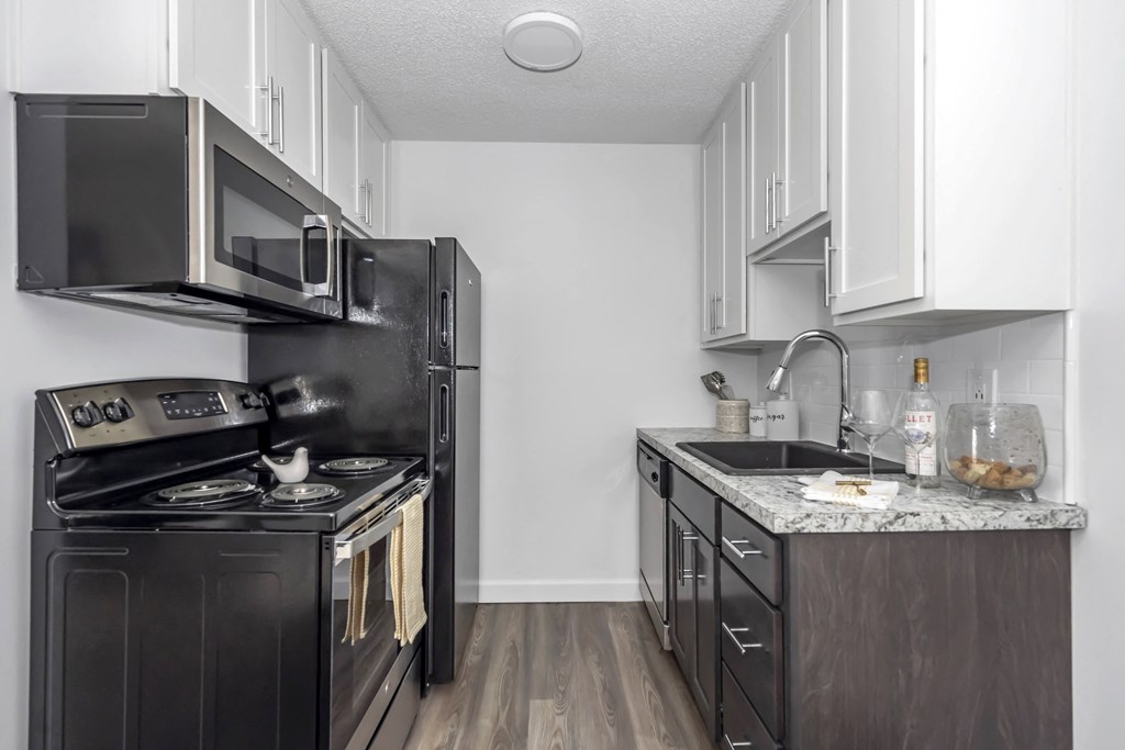 Kitchen with black appliances and white cabinets and a black refrigerator at Tall Timber Apartments, Cincinnati