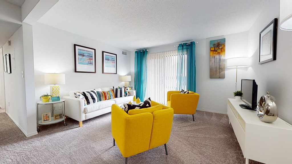 a living room with yellow chairs and a white couch