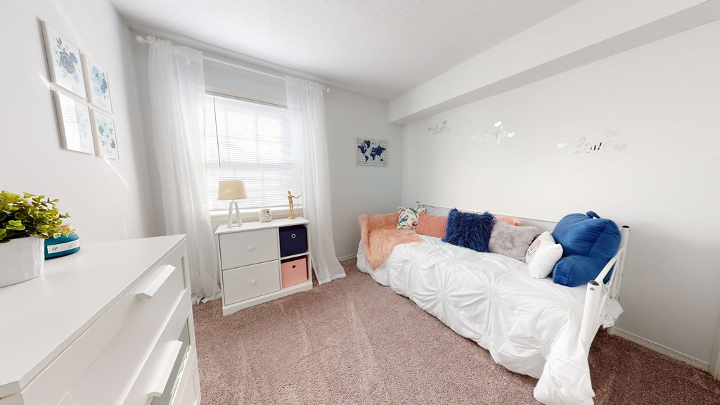 a bedroom with a bed and a dresser and a window