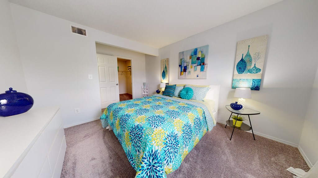 a bedroom with a bed and paintings on the wall