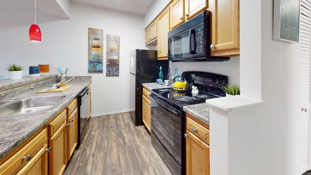our apartments have a modern kitchen with wood cabinets and black appliances