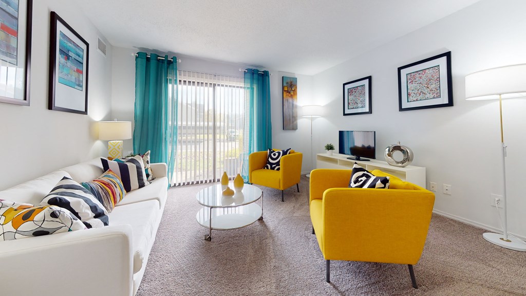 living room with yellow couches and chairs and a television