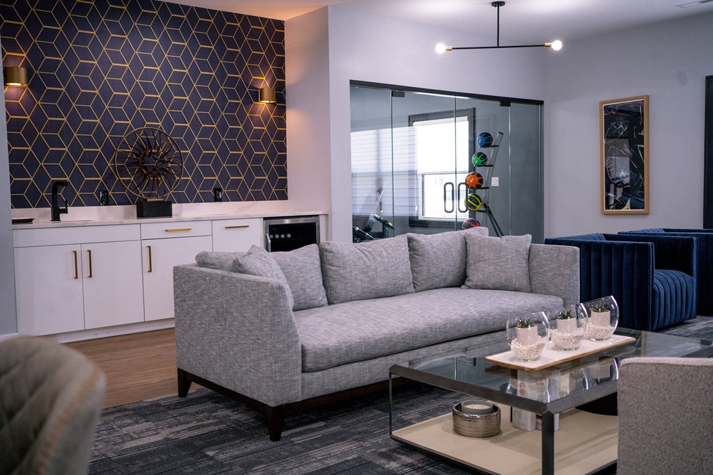 a living room with a gray couch and a glass coffee table