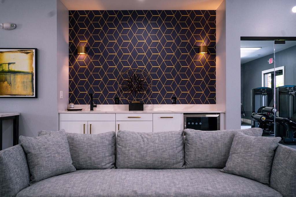 a living room with a couch in front of a wall with a geometric design