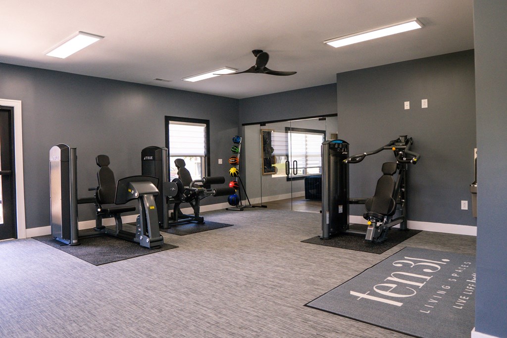 a gym with weights and cardio equipment in an empty room