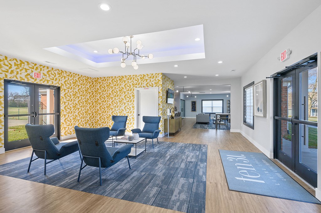 a lobby with blue chairs and yellow wallpaper and a blue rug