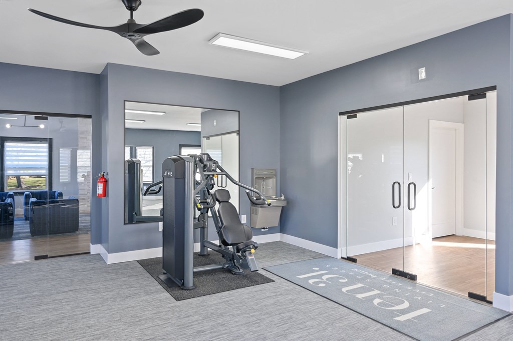 a gym with a treadmill and a mirror and a door