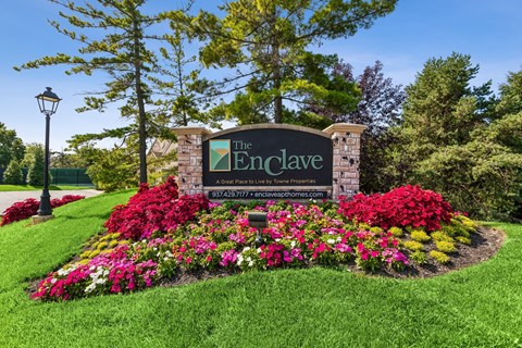 The Enclave sign is surrounded by a beautiful flower bed.