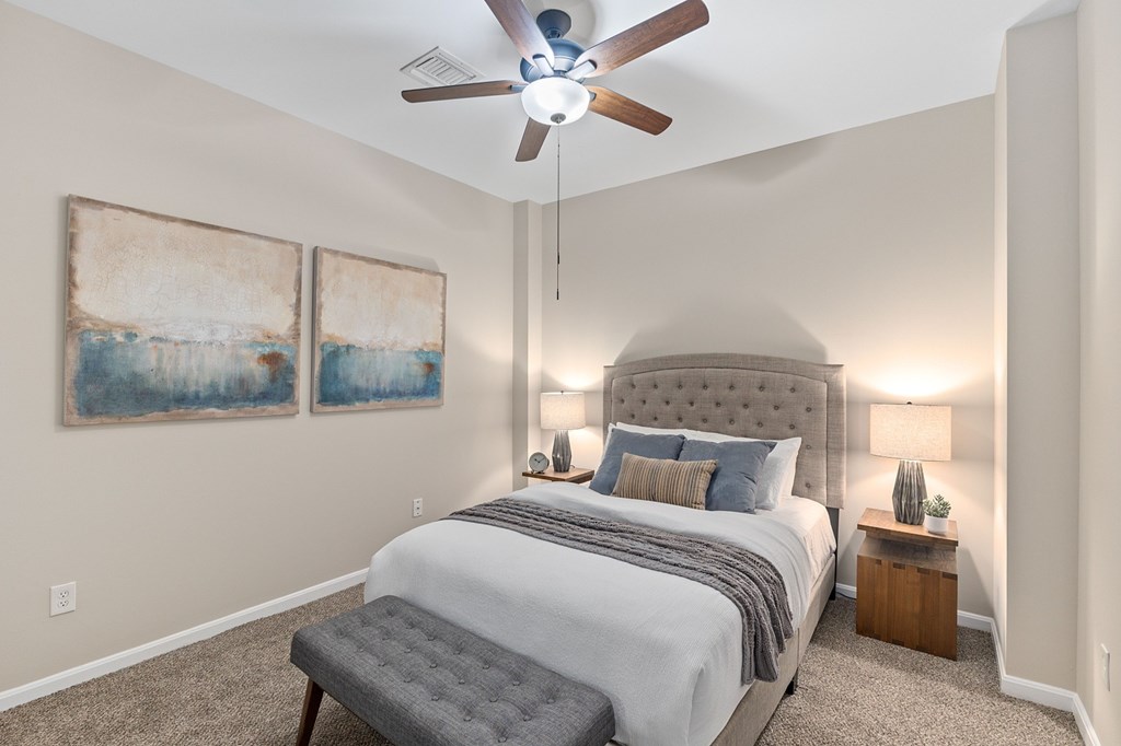 A bedroom with a large bed and a ceiling fan.
