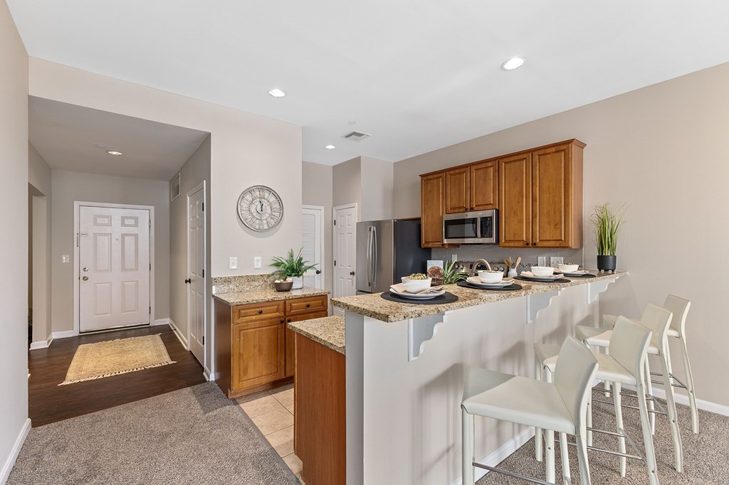 A kitchen with a white counter top and a white fridge.