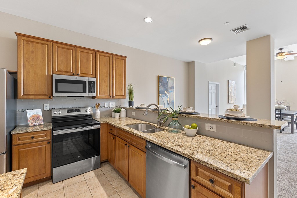 A kitchen with granite countertops and stainless steel appliances.