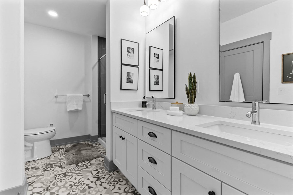 A bathroom with a white toilet, a sink, and a mirror. at The Ridge Apartments, Cincinnati, OH, 45213