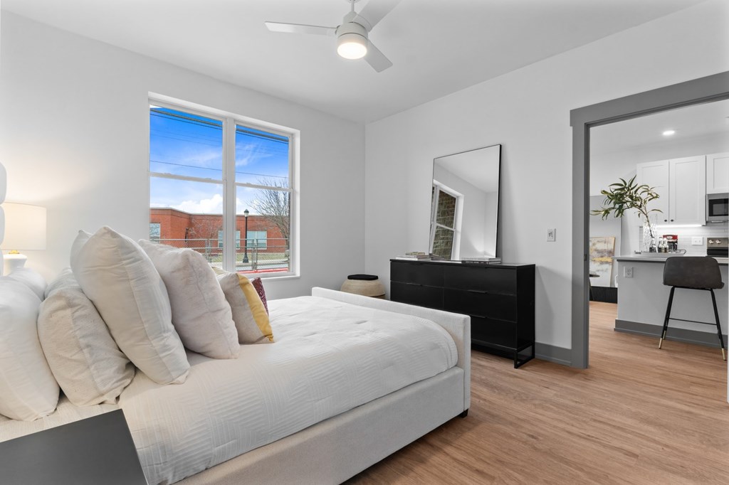 A bedroom with a large bed and a dresser with a mirror. at The Ridge Apartments, Cincinnati, Ohio