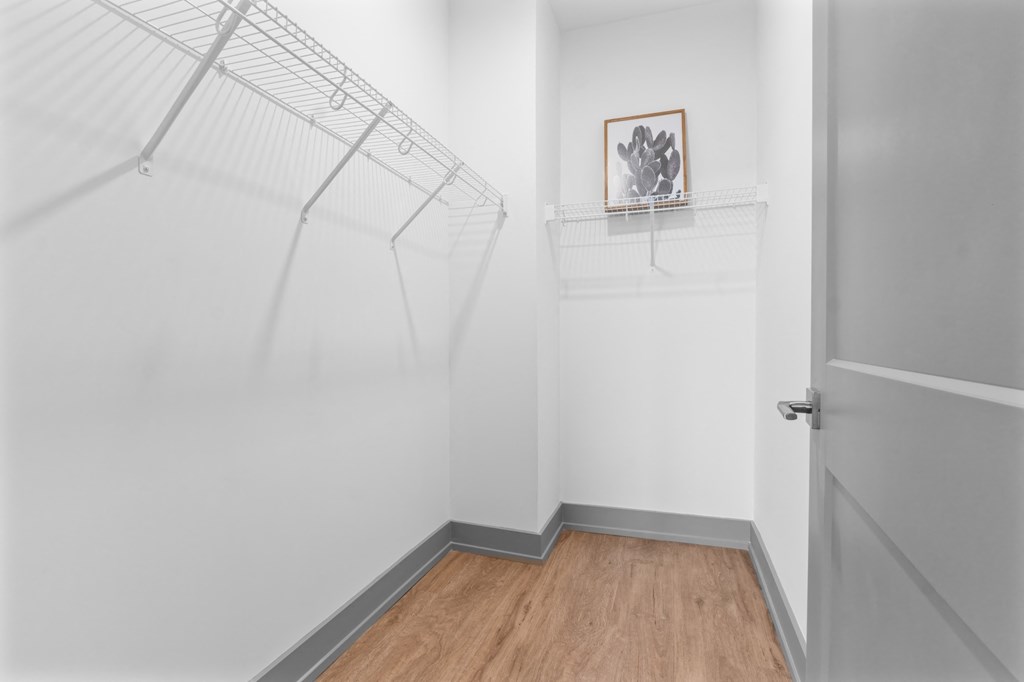 A white hallway with a wooden floor and a white door. at The Ridge Apartments, Cincinnati, OH