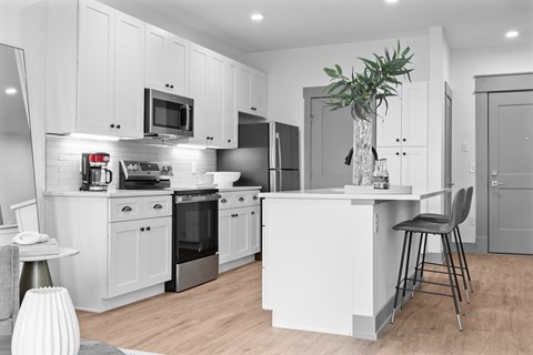A modern kitchen with white cabinets and stainless steel appliances.