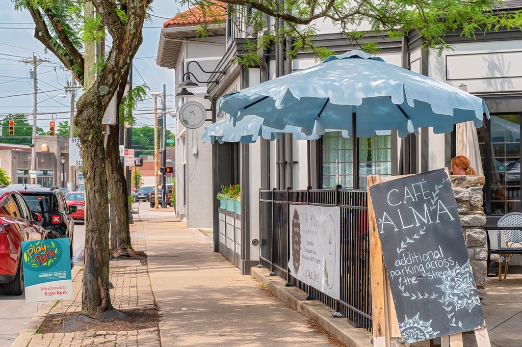 A blue umbrella is on the sidewalk in front of a cafe. at The Ridge Apartments, Cincinnati, Ohio