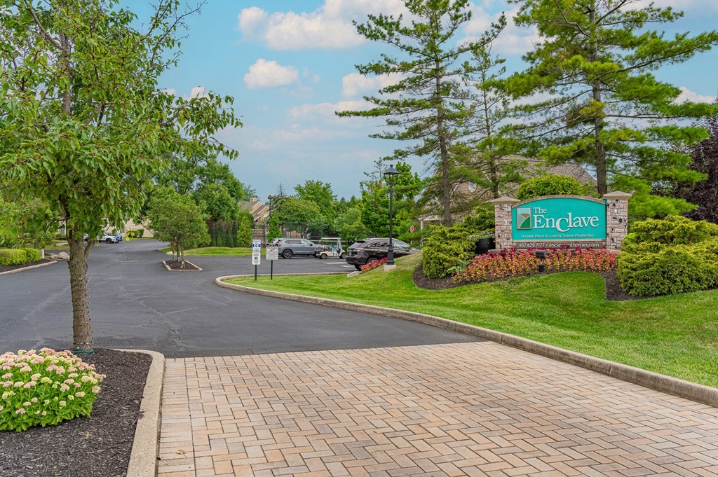a view of the entrance sign at the enclave at woodbridge apartments in sugar land, tx