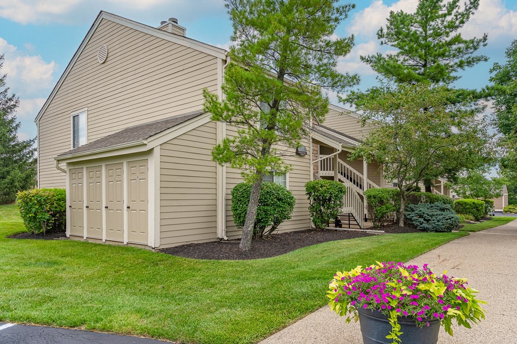a house with a garage and a driveway with a potted plant on the side of the at Enclave, Beavercreek