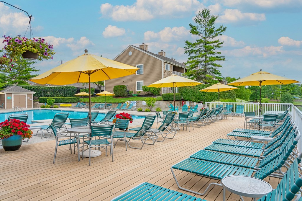 a swimming pool with chaise lounge chairs and umbrellas