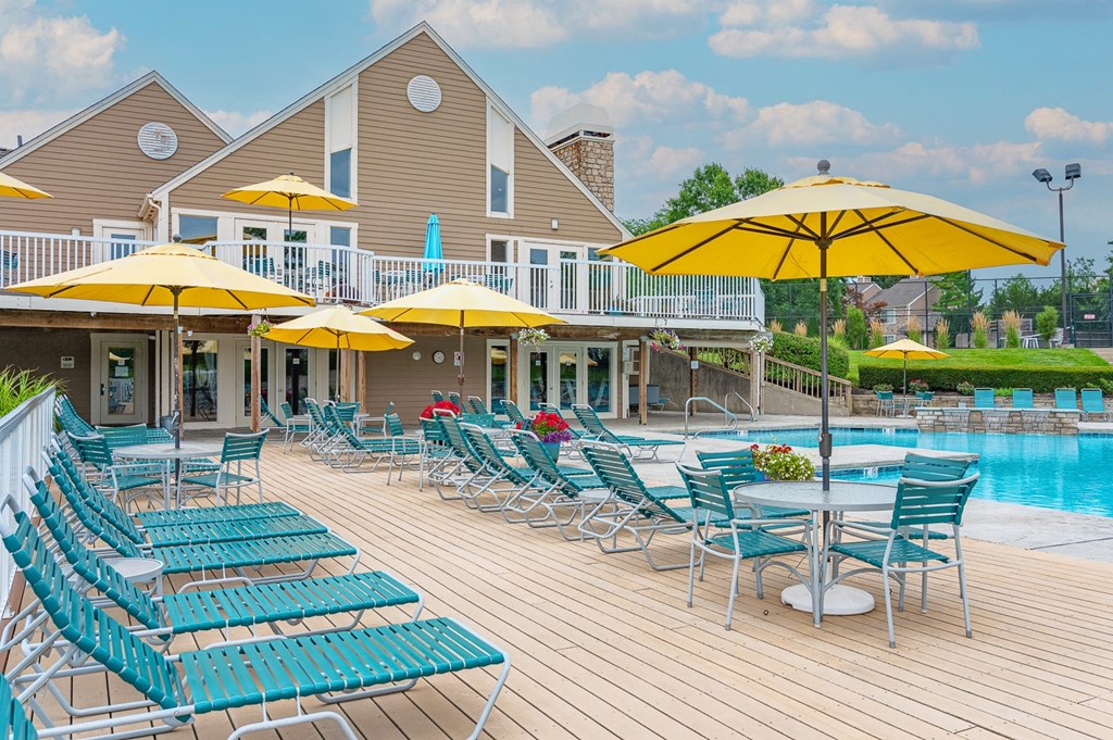a swimming pool with chaise lounge chairs and umbrellas