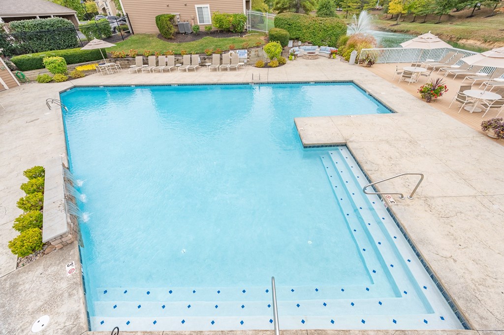 A large blue swimming pool with a diving board.