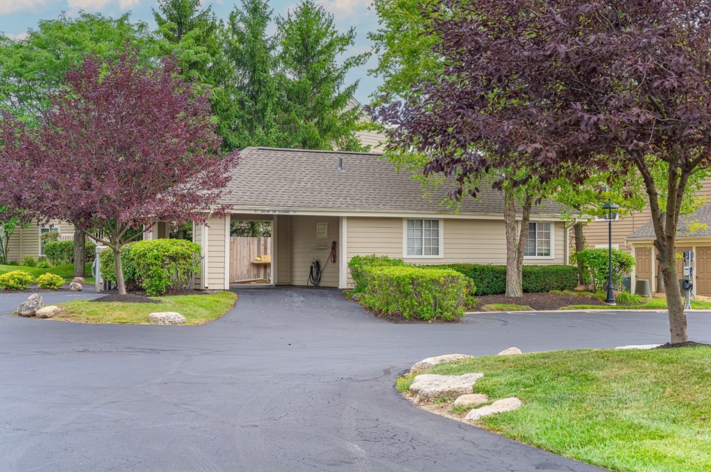 A house with a driveway and trees in front.
